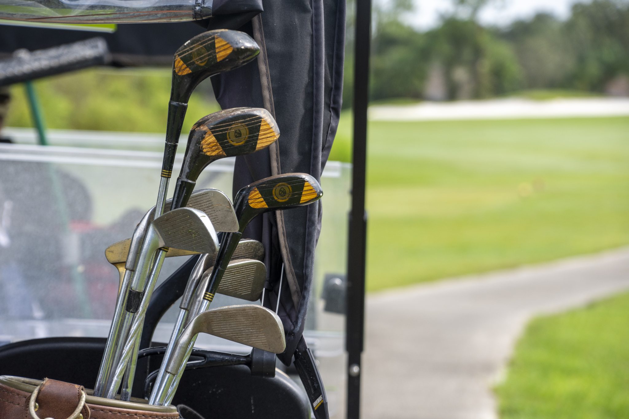 Golf clubs and bag staged on the back of a golf cart