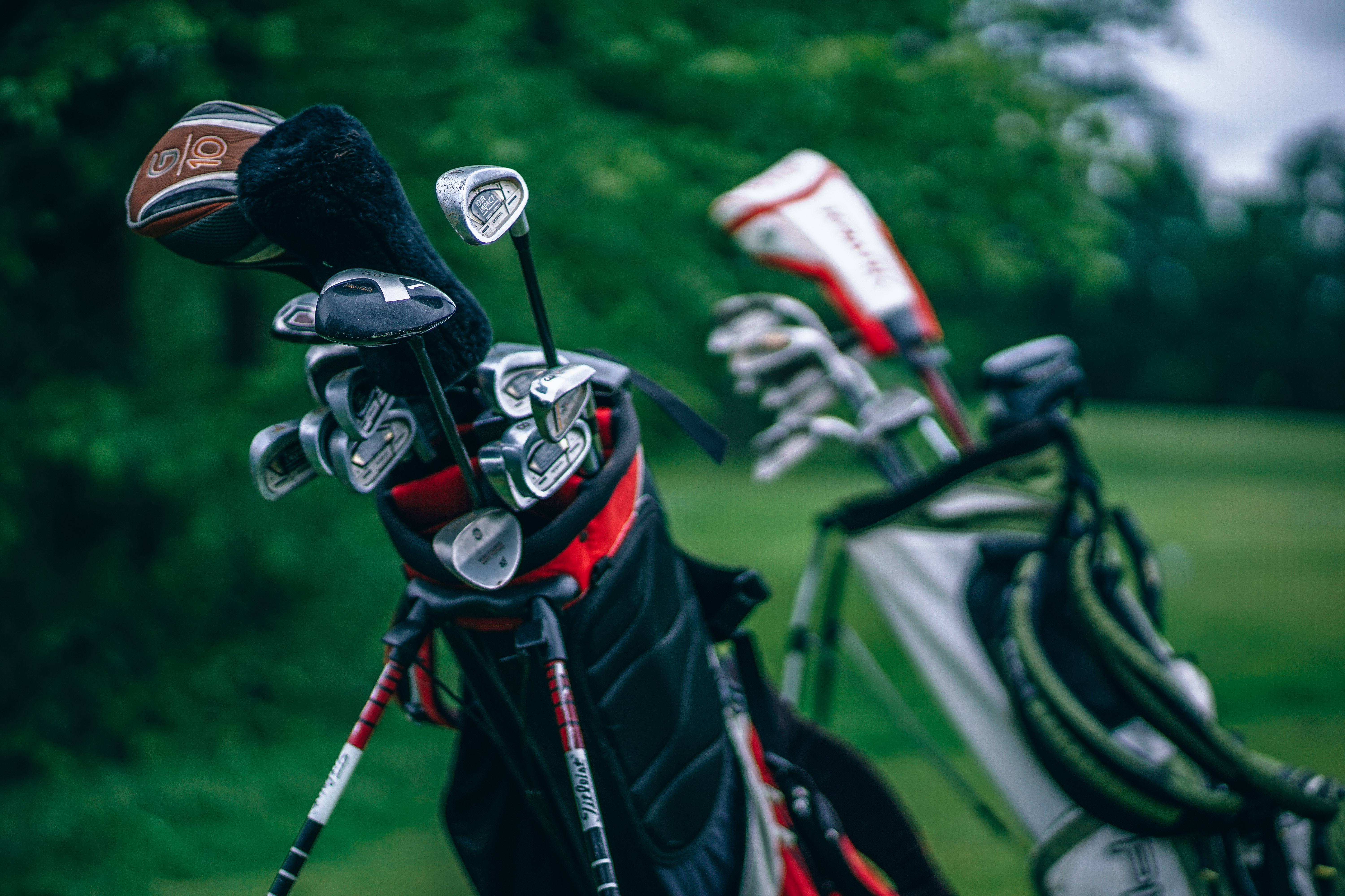 Two bags full of golf clubs (Unsplash)