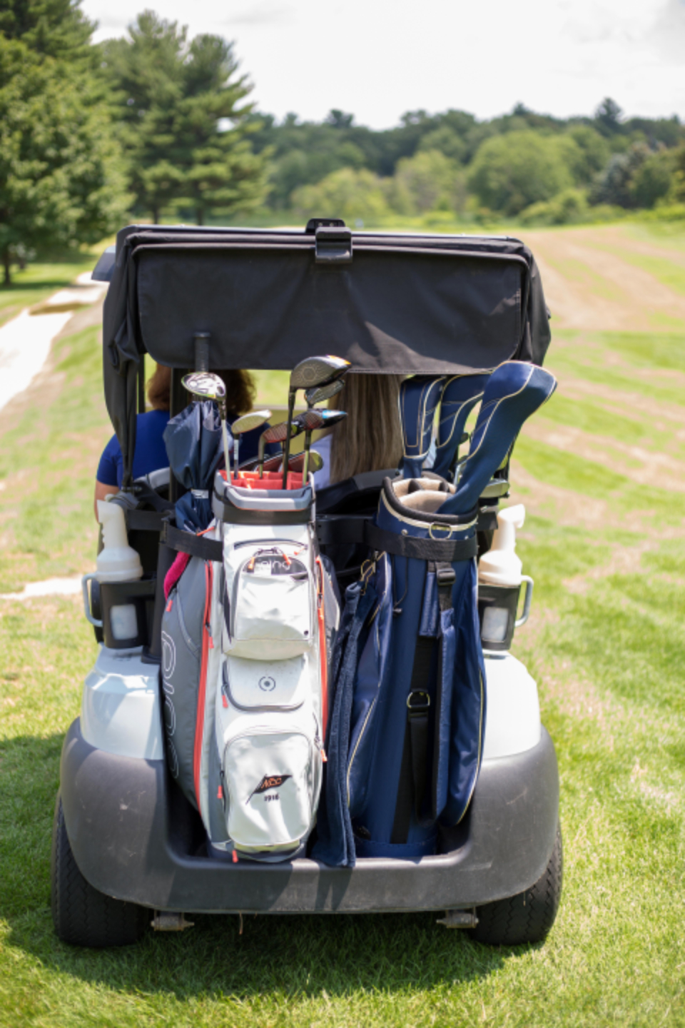 Golf bags loaded on a golf cart for movement along the course