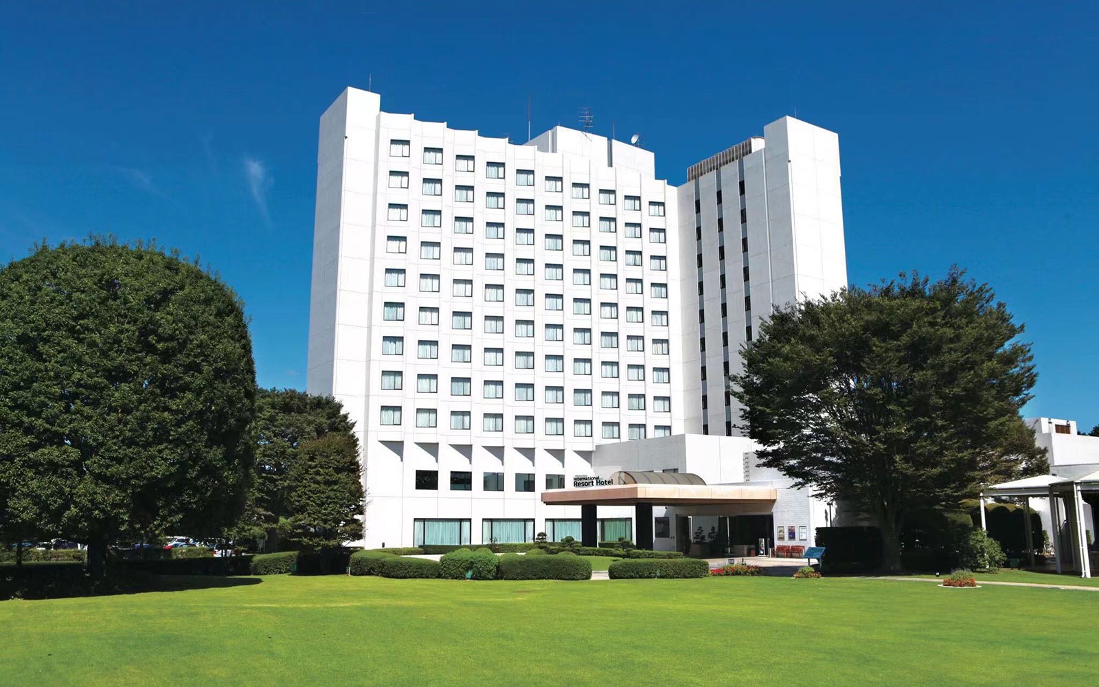 International Resort Hotel Yurakujo 본관 외관과 잔디 앞마당